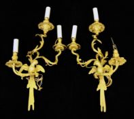 A pair of modern Régence style gilt bronze wall lights, each stem in the form of a parrot on a