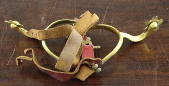 A pair of 19th century gilt metal spurs, with red leather straps, 4in.