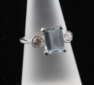 An 18ct white gold aquamarine and diamond dress ring, set with emerald cut aquamarine flanked by