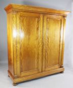 A late 19th century Dutch satin walnut wardrobe, with moulded cornice and two panelled doors, on