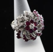 An 18ct white gold ruby and diamond set dress ring, of whorl design, with triple band pierced shank,
