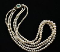 A triple strand graduated cultured pearl choker necklace with cultured pearl and emerald set gold