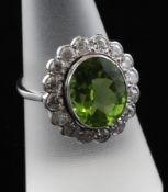 An 18ct white gold, peridot and diamond cluster ring, of oval form, the central 5.00ct peridot