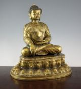 A large Tibetan gilt bronze figure of Buddha, 18th century, seated in dhyanasana on a separate
