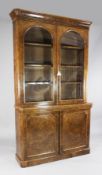 A Victorian burr walnut bookcase, with rounded cornice, two arched glazed doors and panelled