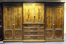 A large Victorian olive wood breakfront wardrobe, fitted a central linen press section with two