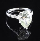 A platinum and pear shaped solitaire diamond ring, with diamond set shoulders and central stone