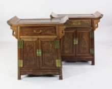 A pair of Chinese hardwood side cabinets, each fitted with a frieze drawer and two doors carved in