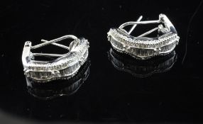 A pair of 18ct white gold, baguette and round cut diamond set half hoop earrings.