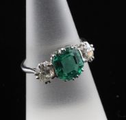 A platinum and three stone emerald and diamond set ring, the central Columbian emerald from the