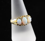 An Edwardian 18ct gold, three stone opal and diamond chip dress ring, size Q.