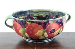 A William Moorcroft pomegranate pattern two handled bowl, with green to blue graduated ground,