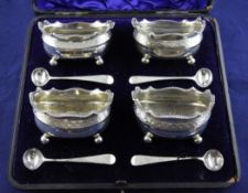 A matched set of four George III silver table salts, of rounded rectangular form, with engraved