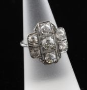 A 1920`s white gold and seven stone diamond tablet dress ring, of cruciform design, set with old cut