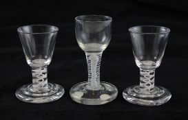 A pair of George III firing glasses and one other similar, c.1765, the pair with rounded funnel