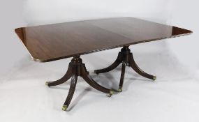 A Regency design three pillar extending dining table, with rounded corners, two extra leaves, reeded