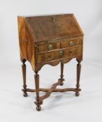 A late 17th / early 18th century featherbanded walnut bureau, the fall front with stepped interior