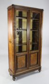A 19th century continental amboyna bookcase, with two glazed doors and birds eye maple veneered