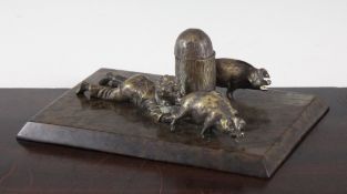 A 19th century figural bronze inkwell, modelled as a recumbent boy holding two pigs, on a