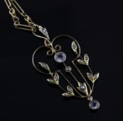 An Edwardian 15ct gold, beryl and seed pearl set foliate scroll pendant, on a 15ct gold chain (