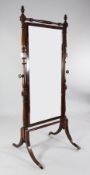 A Victorian mahogany cheval glass, with turned stiles and downswept legs, fitted brass caps and