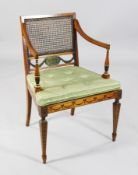 An Edwardian Sheraton revival painted satinwood elbow chair, with caned back and seat