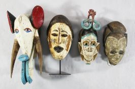 Four 20th century African carved and painted masks from the Ivory Coast, largest modelled as an