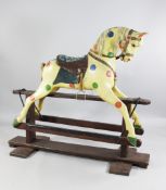 A large 20th century carved and painted rocking horse, on a stained beech base, L.5ft