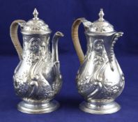 A late Victorian/Edwardian silver cafe au lait pair, of baluster form, with embossed foliate