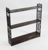 A set of George III mahogany hanging shelves, with gothic arched pierced panel sides and two