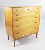 A mid 20th century walnut chest, of five long drawers with brass handles, on shaped supports, by