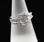 A modern 18ct white gold and diamond ring with vacant raised claw setting, the shank and border
