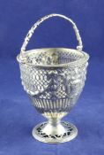A George III pierced repousse silver sugar basket, of vase form, decorated with vase of flowers