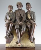 An Austrian painted terracotta model of three negro boys seated on a wall, unmarked, possibly