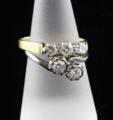 An 18ct white gold two stone illusion set diamond cross-over ring, size N and an 18ct gold three