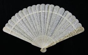 A Chinese ivory brise fan, 19th century, the sticks carved and pierced with figures amid pavilions