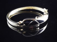 A modern stylish 14ct gold and black enamel stiff bracelet.