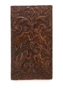 A CARVED OAK PANEL, LATE 17TH CENTURY, carved with four frolicking putti within foliate scroll,