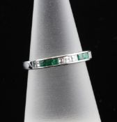 An 18ct white gold emerald and diamond half eternity ring, set with eleven stones, size M.