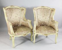 A pair of Louis XV design pale yellow and parcel gilt armchairs, with floral patterned and silk