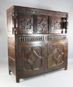 An 18th century and later carved oak court cupboard, with an arrangement of four geometric moulded