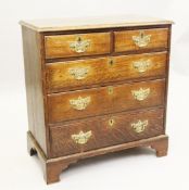 A mid 18th century oak chest, fitted two short and three long graduated drawers, with later