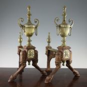 A pair of Victorian brass fire andirons, mounted a classical two handled urn on animal leg and