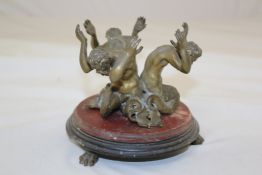 A 19th century bronze merman and marble stand, the three figures with their arms raised aloft, on