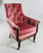An early 19th century pink upholstered button back tub shaped library chair, with scroll arms and