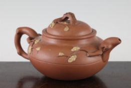 A Chinese Yixing pottery compressed globular teapot, decorated with prunus blossom sprigs with