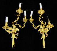 A pair of modern Régence style gilt bronze wall lights, each stem in the form of a parrot on a
