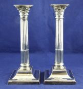 A pair of Victorian silver corinthian column candlesticks, with engraved crest and fluted filleted