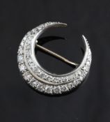 A Victorian style gold and diamond set crescent brooch, with two rows of graduated round cut stones,