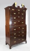 A George III mahogany secretaire chest on chest, the broken swan neck pediment and applied gilt